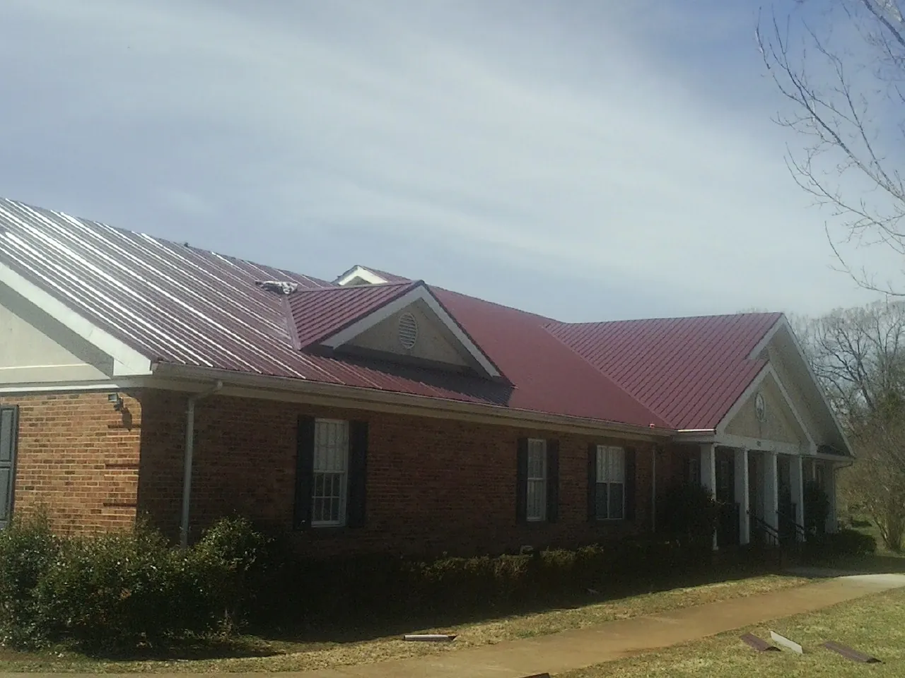 Red metal roof with gabled entries on a long brick building in Pennsburg