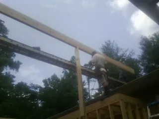 Carpenter setting a ridge beam over a new addition frame — Ice Dam Removal by Roofing Brothers in Pennsburg