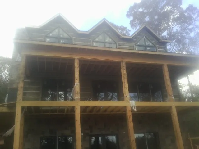 Dormers and porch framing on a large log home under construction — Roof Coating work by our crew in Pennsburg