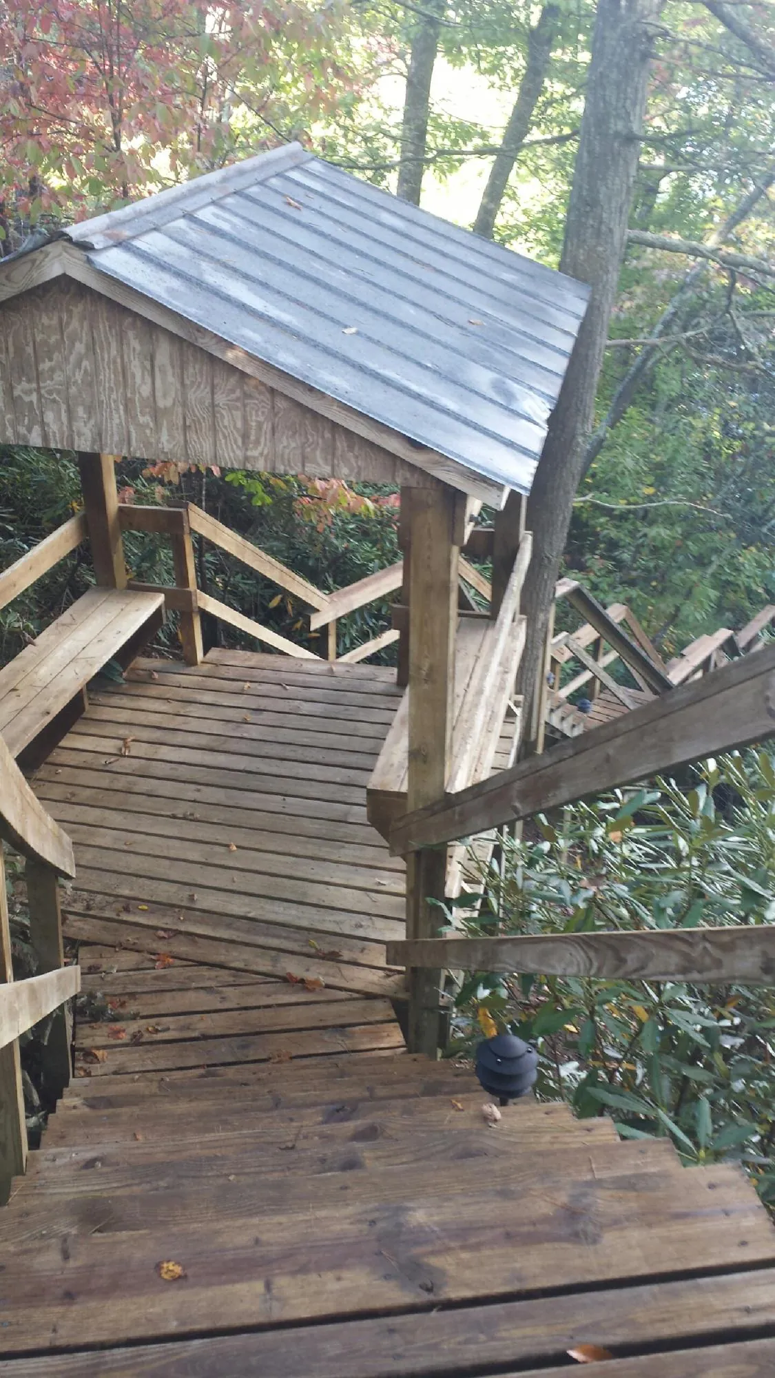Metal roofed shelter over wooden steps on a wooded walkway — Skylight Repair & Installation work by our crew in Pennsburg
