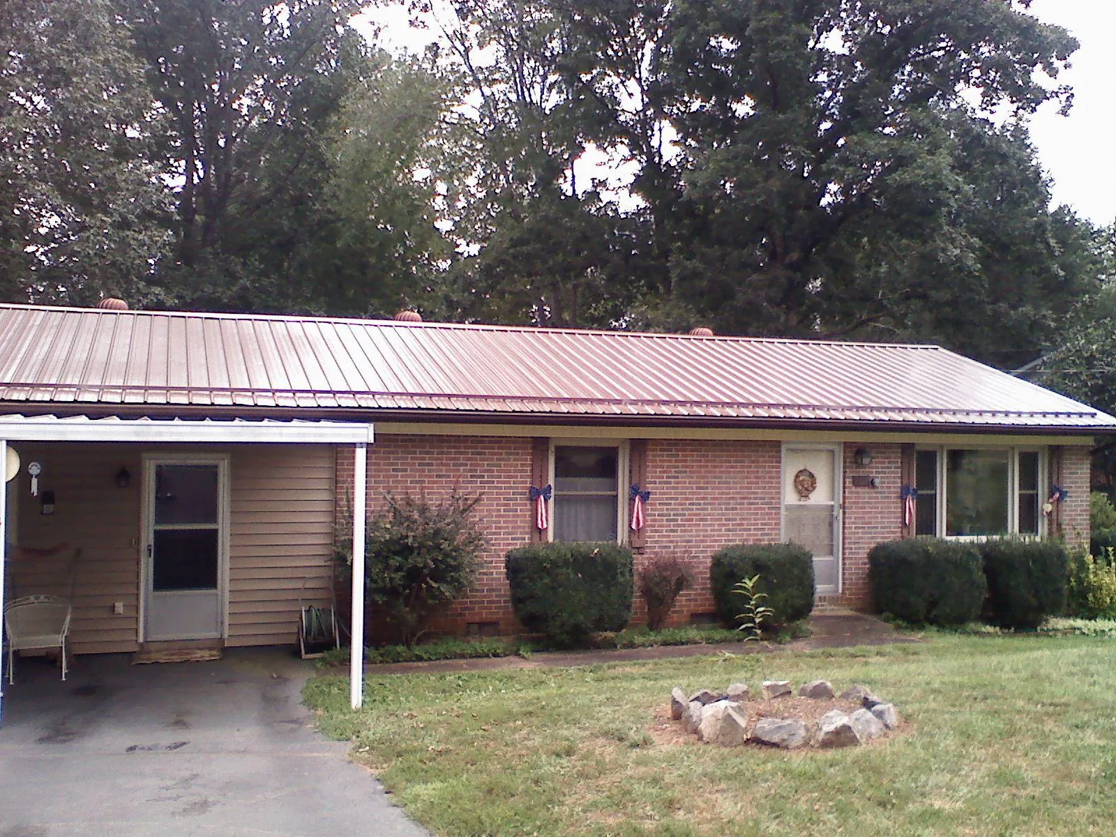 Bronze metal roof and carport on a brick ranch home — Roof Repair work by our crew in Pennsburg